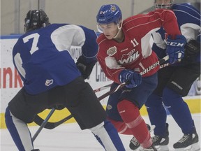 Brett Kemp (red) tries to stickhandle past Logan Holm during an Edmonton Oil Kings training camp game at Rogers Place, Aug. 27, 2018
