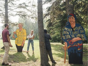 Wendy Mulder and her eight-week-old daughter Ember Mulder Goutbeck pose Sunday with their likeness at a kick-off event in Whitemud Park for "People on the Path", a collaborative art installation created by Climate Justice Edmonton in opposition to the Trans Mountain Pipeline Expansion. (AMBER BRACKEN/POSTMEDIA)