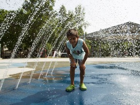 Joshua Genest, 9, plays in the water on a plus-30 degree C day at McKernan Spray Park. Community leagues work with the city to get these facilities built but have been struggling with what they see as an overly onerous process.