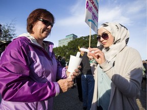 Karen Szabcik (left) and Batoul Istabouly light candles during a Refugees Welcome rally held at the Alberta Legislature in Edmonton, Alta., on Tuesday September 8, 2015. File photo.