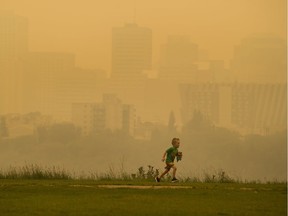 The city skyline is obscured by smoke from fires in British Columbia but that doesn't discourage Malcolm Redpath, 4, from Nova Scotia from having fun on Wednesday, Aug. 15, 2018 in Edmonton.