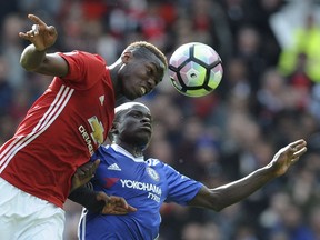 In this Sunday, April 16, 2017 photo Manchester United's Paul Pogba and Chelsea's N'Golo Kante, rear, challenge for the ball during the English Premier League soccer match between Manchester United and Chelsea at Old Trafford stadium in Manchester.