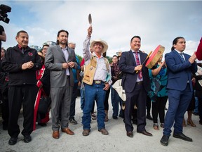 Coldwater Indian band Chief Lee Spahan, centre, raises an eagle feather before he and other First Nations leaders respond to a Federal Court of Appeal ruling on the Kinder Morgan Trans Mountain Pipeline expansion, during a news conference in Vancouver, on Thursday August 30, 2018. In a unanimous decision by a panel of three judges, the court says the National Energy Board's review of the project was so flawed that the federal government could not rely on it as a basis for its decision to approve the expansion.