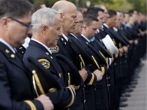 Firefighters take part in a moment of silence during the Edmonton Firefighters Memorial Society's annual remembrance ceremony at the Firefighters Memorial Plaza, 10322 83 Ave., in Edmonton on Tuesday, Sept. 11, 2018.