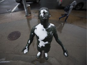 A pedestrian trudges past a snow covered portion of the sculpture InScope, created by Dam de Nogales, near 87 Avenue and 112 Street, Thursday Sept. 13, 2018.