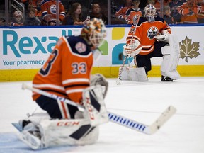 Edmonton Oilers goalie Mikko Koskinen , right, looks on as goalie Cam Talbot makes a save during warm-up before their NHL pre-season game on Sept. 20, 2018, against the Winnipeg Jets at Edmonton's Rogers Place.