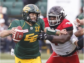 Calgary Stampeders Micah Johnson (4) grabs Edmonton Eskimos quarterback Mike Reilly (13) during first half CFL action in Edmonton on Saturday September 8, 2018.