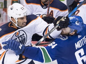 Vancouver Canucks center Tyler Motte (64) fights for control of the puck with Edmonton Oilers' Jason Garrison during first period NHL pre-season action at Rogers Arena in Vancouver, Tuesday, Sept, 18, 2018. THE CANADIAN PRESS/Jonathan Hayward