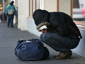 A homeless person huddles from the cold in front in downtown Edmonton in this file photo.