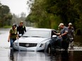 Members of a private critical crisis search and rescue team inspect a vehicle partially submerged in floodwaters during Tropical Storm Florence in Beulaville, North Carolina, U.S., on Sunday, Sept. 16, 2018.