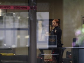 An Edmonton police officer and police tape was visible in the lobby of Rossdale House, 9825 103 Street, on the morning of Sept. 12, 2018.