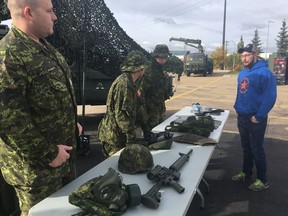 Sgt. Dan Pagnutti (left) speaks with potential recruit Marcel Brouillette at a Canadian Army Reserves event at Debney Armoury in Edmonton on Sept. 29, 2018. The reserves are working to add 1,500 additional troops.