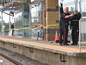A backpack and jacket lay behind police officers where a young man was stabbed while waiting on the platform of the South Campus LRT station in Edmonton, September 18, 2018. Ed Kaiser/Postmedia