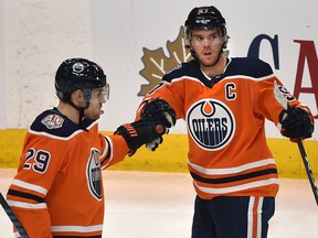 Edmonton Oilers star Connor McDavid, right, celebrates his second goal against the Calgary Flames with teammate Leon Draisaitl during pre-season NHL action at Rogers Place in Edmonton on Sept. 29, 2018.