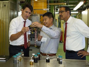 Prime Minister Justin Trudeau, left, director of hydrocarbon conversion Jinwen Chen and then Natural Resources Minister Amarjeet Sohi at the Canmet Energy Devon Research Centre on Sept. 4, 2018.