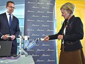 Premier Rachel Notley shakes hands with a robot arm controlled by Marlin Schmidt, Minister of Advanced Education, at a news conference announcing new tech sector program spaces at the University of Alberta in Edmonton, September 13, 2018.