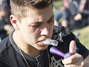Troy Madge takes a hit off a pipe during 420 festivities at the Alberta Legislature Building in Edmonton, Alta. on Monday, April 20, 2015. File photo.