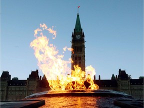 The Centre Block of the Parliament Buildings is shown through the Centennial Flame on Parliament Hill in Ottawa on Sunday, January 25, 2015.