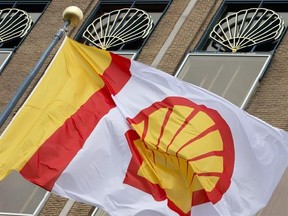 FILE - In this Monday, April 7, 2014 file photo, a flag bearing the company logo of Royal Dutch Shell, flies outside the head office in The Hague, Netherlands. Royal Dutch Shell said fourth-quarter earnings tumbled 44 percent as the collapse in oil prices took its toll on another European oil company. Profit adjusted for changes in the value of inventories and one-time items dropped to $1.83 billion from $3.26 billion in the same period a year earlier, the Anglo-Dutch energy giant said Thursday