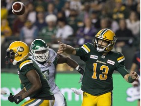 Edmonton Eskimos' Mike Reilly (13) battles the Saskatchewan Roughriders during second half CFL action at Commonwealth Stadium, in Edmonton Thursday Aug. 2, 2018. The Eskimos won 26 to 19. Photo by David Bloom