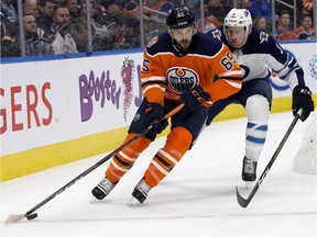 Edmonton Oilers forward Cooper Marody battles the Winnipeg Jets defenceman Tucker Poolman during pre-season NHL action at Rogers Place in Edmonton on Sept. 20, 2018.