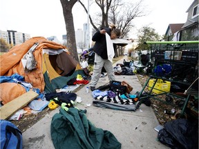 Kenny Cardinal packs up his tent and belongings along 105A Avenue near 96 Street in Edmonton on Oct. 15, 2018. A proposal by Redemptive Developments would help to get single people off the streets and into affordable housing.