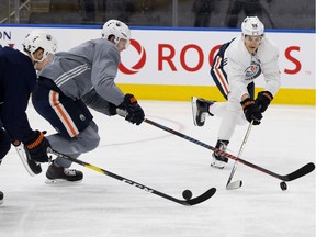 Alex Chiasson, left, Oscar Klefbom, and Jesse Puljujarvi take part in an Edmonton Oilers practice at Rogers Place in Edmonton on Friday, Oct. 26, 2018.