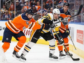 Adam Larsson and Connor McDavid of the Edmonton Oilers battle against Sidney Crosby of the Pittsburgh Penguins at Rogers Place on Nov. 1, 2017. in Edmonton.