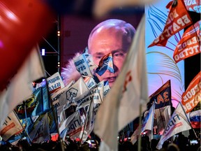 People listen to presidential candidate, President Vladimir Putin during a rally and a concert celebrating the fourth anniversary of Russia's annexation of Crimea at Manezhnaya Square in Moscow on March 18, 2018.