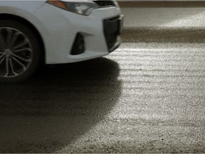 The road glistens in the sunshine after a calcium chloride anti-icing liquid was applied in February 2018.