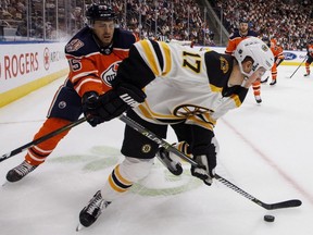 Boston Bruins' Ryan Donato is chased by Edmonton Oilers' Evan Bouchard during NHL action in Edmonton, Oct. 18, 2018.