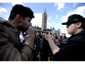 Statistics Canada says about two-thirds of casual cannabis users say they didn't spend anything on the drug in the past three months, chalking it up to a sharing culture among marijuana users. A man shares a his marijuana joint during the annual 4/20 marijuana celebration on Parliament Hill in Ottawa on Friday, April 20, 2018.