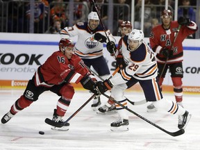 Cologne's Tobias Viklund, left, and Oiler's Leon Draisaitl fight for the puck during a hockey test match between Koelner Haie (Cologne Sharks) and the Edmonton Oilers in Cologne, Germany, Wednesday, Oct. 3, 2018.