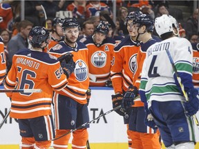 Vancouver Canucks' Michael Del Zotto (4) skates past as Edmonton Oilers' Kailer Yamamoto (56), Ty Rattie (8), Evan Bouchard (75) and Jesse Puljujarvi (98) celebrate a goal during second period preseason action in Edmonton, Alta., on Tuesday September 25, 2018.