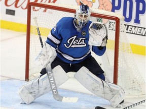 Winnipeg Jets goaltender Laurent Brossoit (30) makes a save against the Carolina Hurricanes during third period NHL hockey action in Winnipeg, Sunday, October 14, 2018.