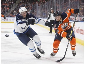 Winnipeg Jets' Tucker Poolman (3) Edmonton Oilers' Alex Chiasson (39) battle for the puck during second period pre-season action in Edmonton, Alta., on Thursday September 20, 2018.