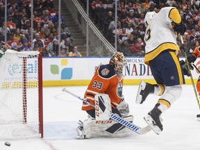 Nashville Predators' Nick Bonino (13) tries to screen Edmonton Oilers' goalie Cam Talbot (33) during first period NHL action in Edmonton on Saturday, Oct. 20, 2018.