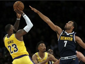 Los Angeles Lakers forward LeBron James, left, shoots an off-balanced shot over Denver Nuggets forward Trey Lyles, right, during the second half of an NBA basketball game in Los Angeles, Thursday, Oct. 25, 2018. Lakers won 121-114.