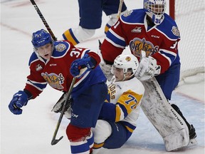 Edmonton Oil Kings Conner McDonald, left, takes down Saskatoon Blades forward Kirby Dach in front of Oil Kings goalie Dylan Myskiw during second period WHL hockey action at Rogers Place, Wednesday, Oct. 3, 2018.