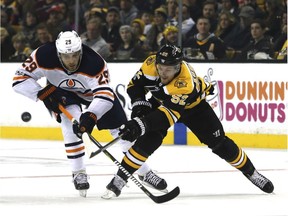 Edmonton Oilers center Leon Draisaitl (29) and Boston Bruins center Sean Kuraly (52) vie for the puck during the second period of an NHL hockey game in Boston, Sunday, Nov. 26, 2017.