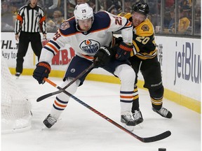 Edmonton Oilers center Leon Draisaitl (29) looks to clear the puck from behind the net ahead of Boston Bruins center Joakim Nordstrom (20) during the second period of an NHL hockey game Thursday, Oct. 11, 2018, in Boston.