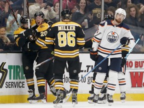 Boston Bruins center Joakim Nordstrom (20) celebrates after scoring a goal with teammates Jake DeBrusk, left, and Kevan Miller (86) as Edmonton Oilers defenseman Adam Larsson (6) skates away during the first period of an NHL hockey game Thursday, Oct. 11, 2018, in Boston. (/)