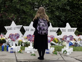 A person stands in front of Stars of David that are displayed in front of the Tree of Life Synagogue with the names of those killed in Saturday's deadly shooting in Pittsburgh.