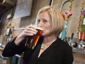 Alberta Premier Rachel Notley drinks a beer while touring the Cold Garden Beverage Company in Calgary on March 27, 2017. The Alberta government is retreating on craft beer subsidies after they were ruled unconstitutional but will open a new front by targeting the province of Ontario for what it says are its unfair trade barriers. Finance Minister Joe Ceci says the province will cancel payments made to assist smaller Alberta craft brewers by Dec. 15 to bring its beer regulations in compliance with Canadian trade law.