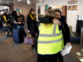 Customer Service Representative Terry Smith (in yellow) hugs a passenger as the last outgoing Greyhound bus prepares to leave the Edmonton Greyhound station, Wednesday Oct. 31, 2018. Greyhound Canada is ending all routes in Alberta on Oct. 31, 2018. Photo by David Bloom