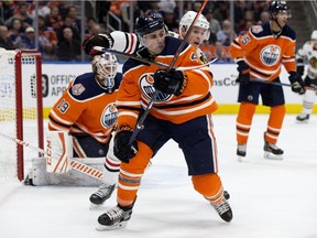 The Edmonton Oilers' Kris Russell (4) battles the Chicago Blackhawks' Jonathan Toews (19) during second period NHL action at Rogers Place in Edmonton Nov. 1, 2018. Photo by David Bloom