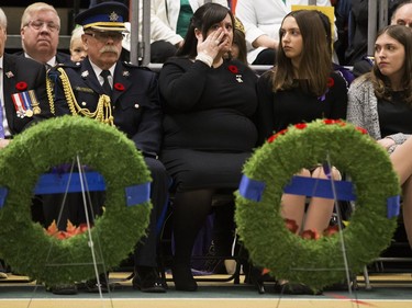 Memorial Cross recipient Lisa Schamehorn - Eades wipes away a tear during the Remembrance Day Service at the University of Alberta's Van Vliet Centre, in Edmonton Sunday Nov. 11, 2018. Her husband, Sgt. Shawn Eades, died Aug. 20, 2008, during his third tour in Afghanistan. Her daughters Niya Eades and Breanna Eades are seated to the right.