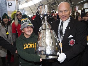 Jada Allibhai, 10, left, helps carry the Grey Cup into Commonwealth Stadium with Jeff McWhinney from the Canadian Football Hall of Fame prior to the start of the Grey Cup, in Edmonton Sunday November 25, 2018. Photo by David Bloom