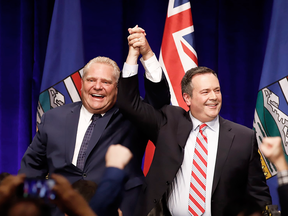 Ontario Premier Doug Ford and United Conservative Party Leader Jason Kenney cheer with supporters at an anti-carbon tax rally in Calgary on Oct. 5, 2018.