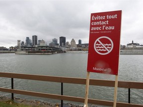 A sign warns to avoid contact with the water along the shore of the St. Lawrence River Friday, November 13, 2015 in Montreal. The city was in the process of dumping eight billion litres of raw sewage into the river while repairs are being made to the sewage collectors. File photo.
